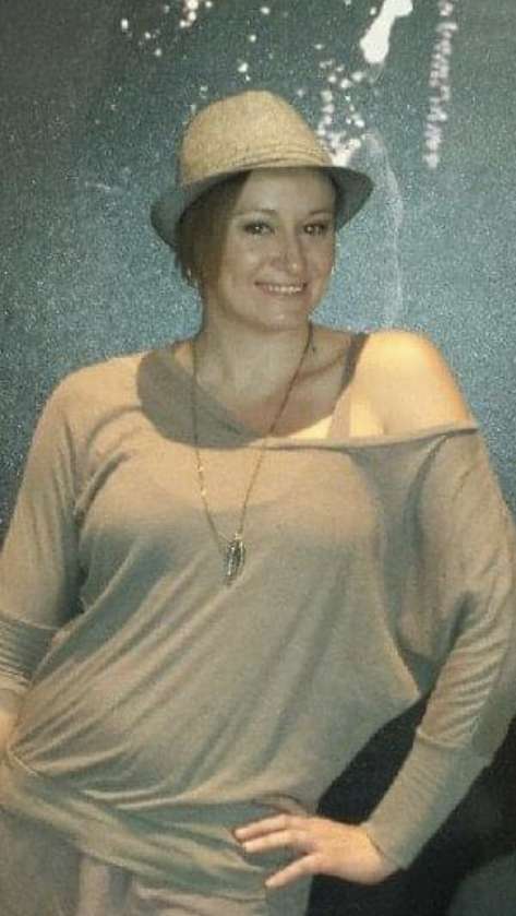42 yr old female in Perimenopause with a smile wearing a brown shirt and hat